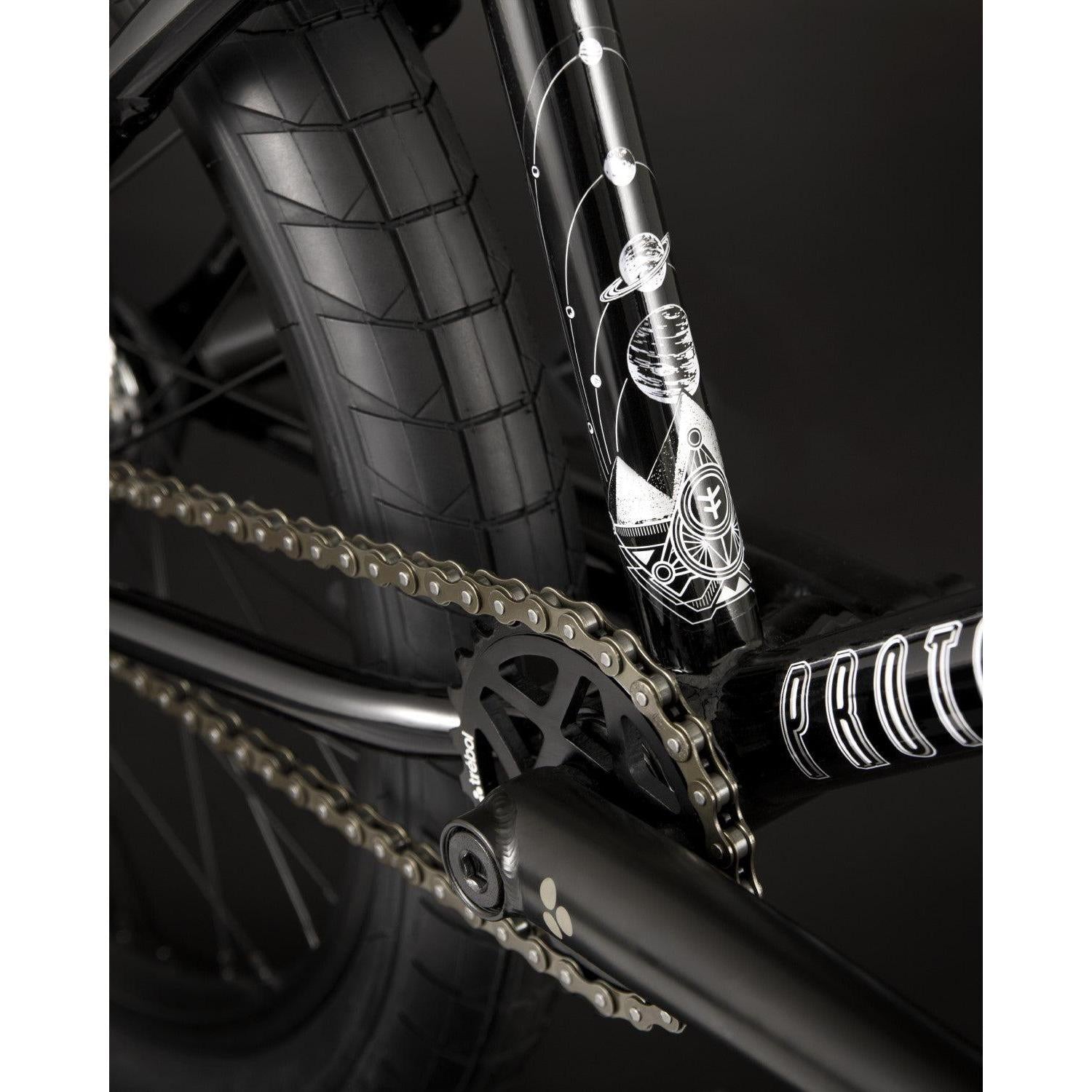 Close-up of the Fly Bikes Proton FC 20 Inch Bike's black BMX chain and CrMo frame, showcasing a detailed astronaut and space-themed design.