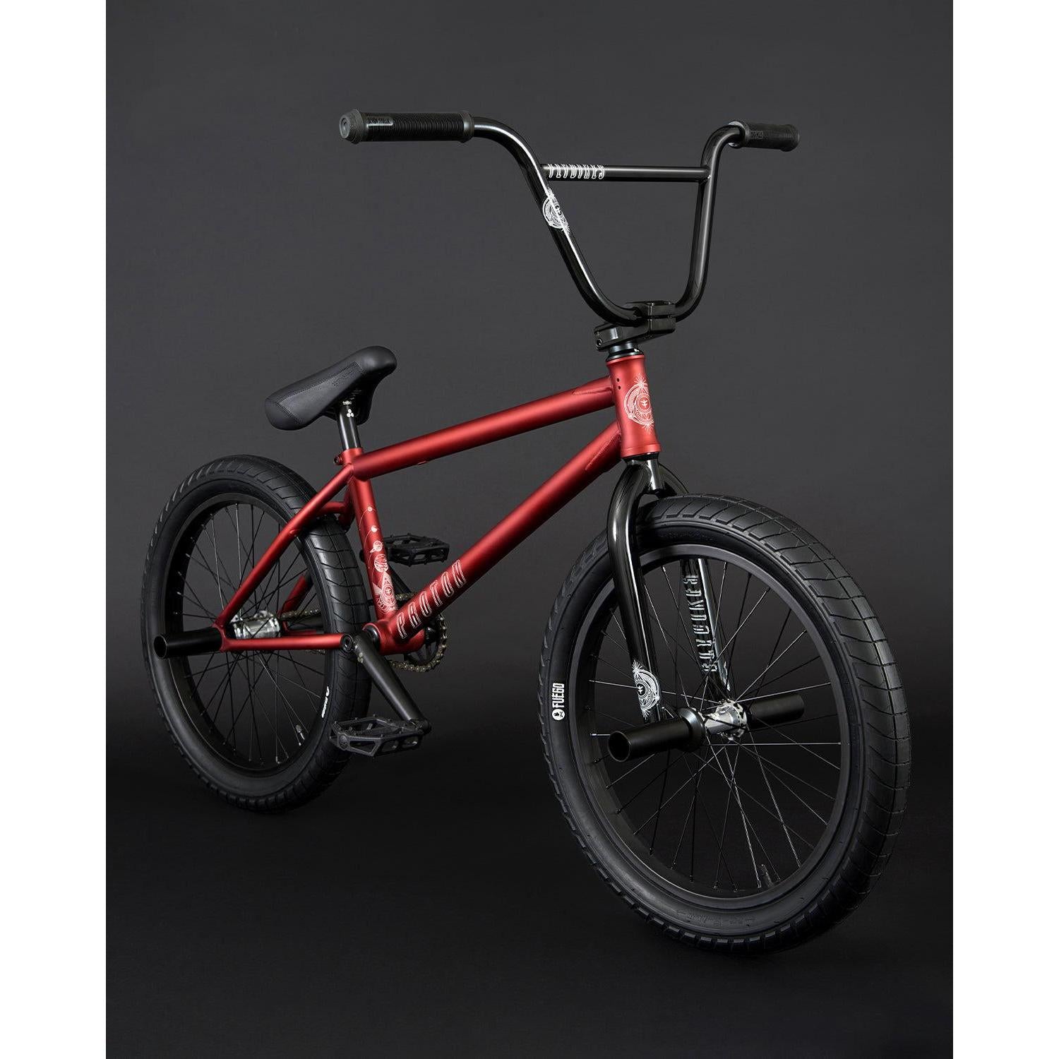 The Fly Bikes Proton FC 20 Inch Bike, with its eye-catching red CrMo frame and black handlebars, is showcased against a dark background, highlighting its sealed hubs for smooth riding.