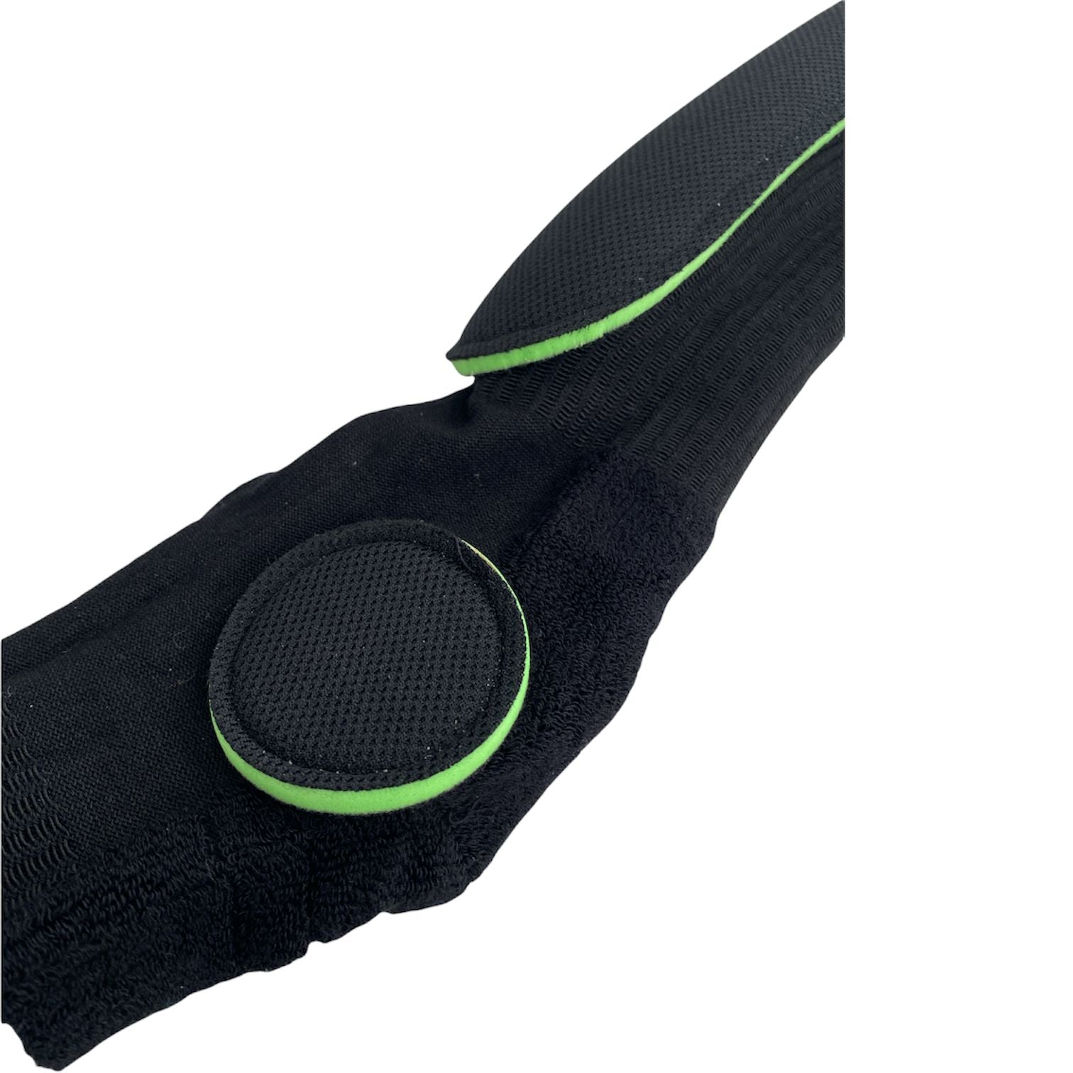 Close-up of a black fabric strap with a round padded section and green trim on a white background, resembling the supportive cushioning in FP Painkiller Socks Crew Cut (Pair).