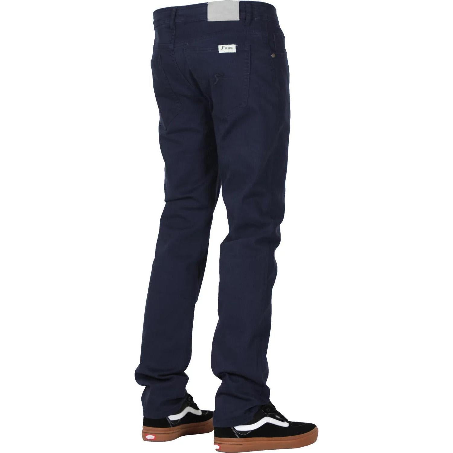 Person wearing dark blue FP Pants Relaxed Fit Chino Blue and black sneakers with white soles, facing away from the camera.