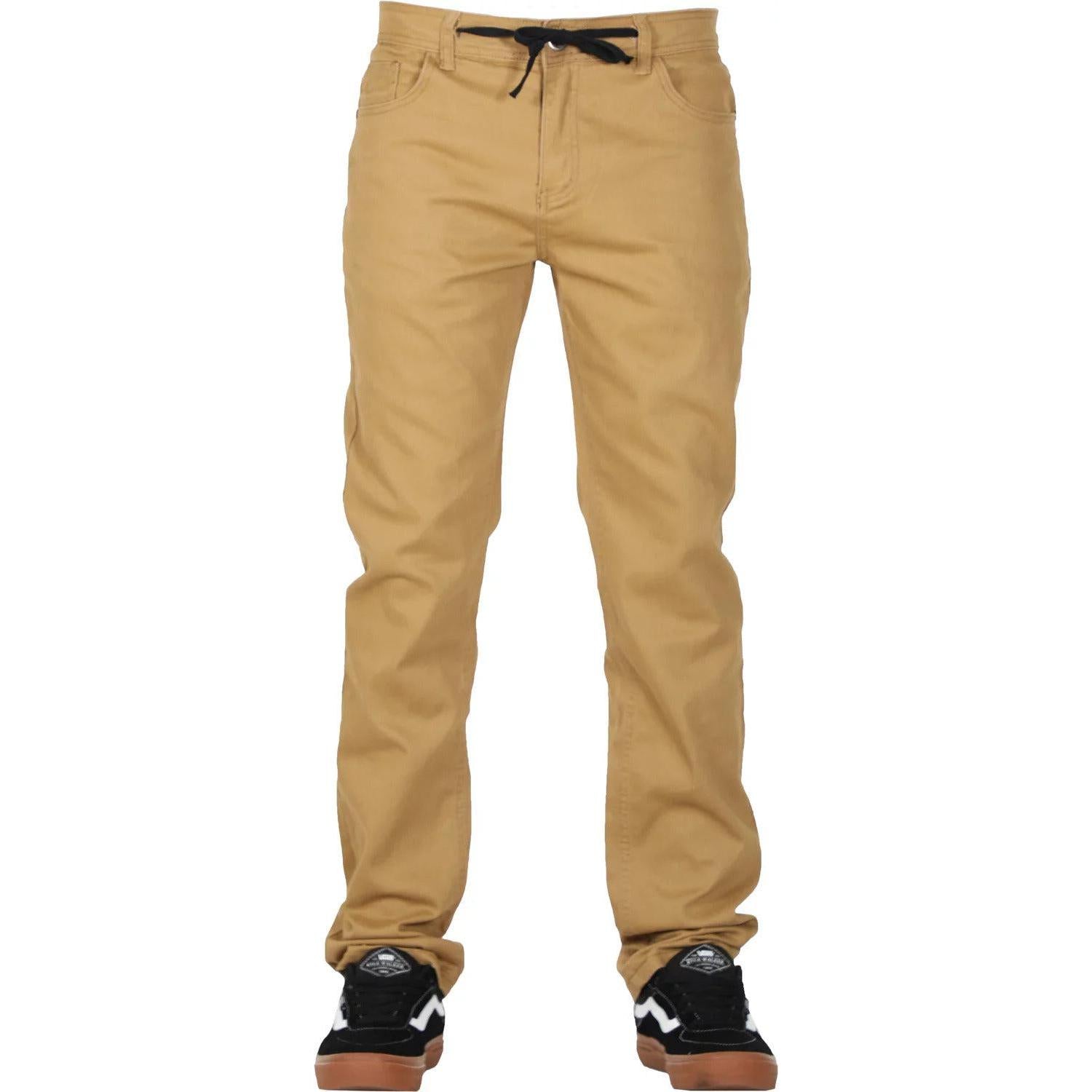 A person wearing relaxed fitting FP Pants Relaxed Fit Chino Bone with a black drawstring and black sneakers with white details, standing.