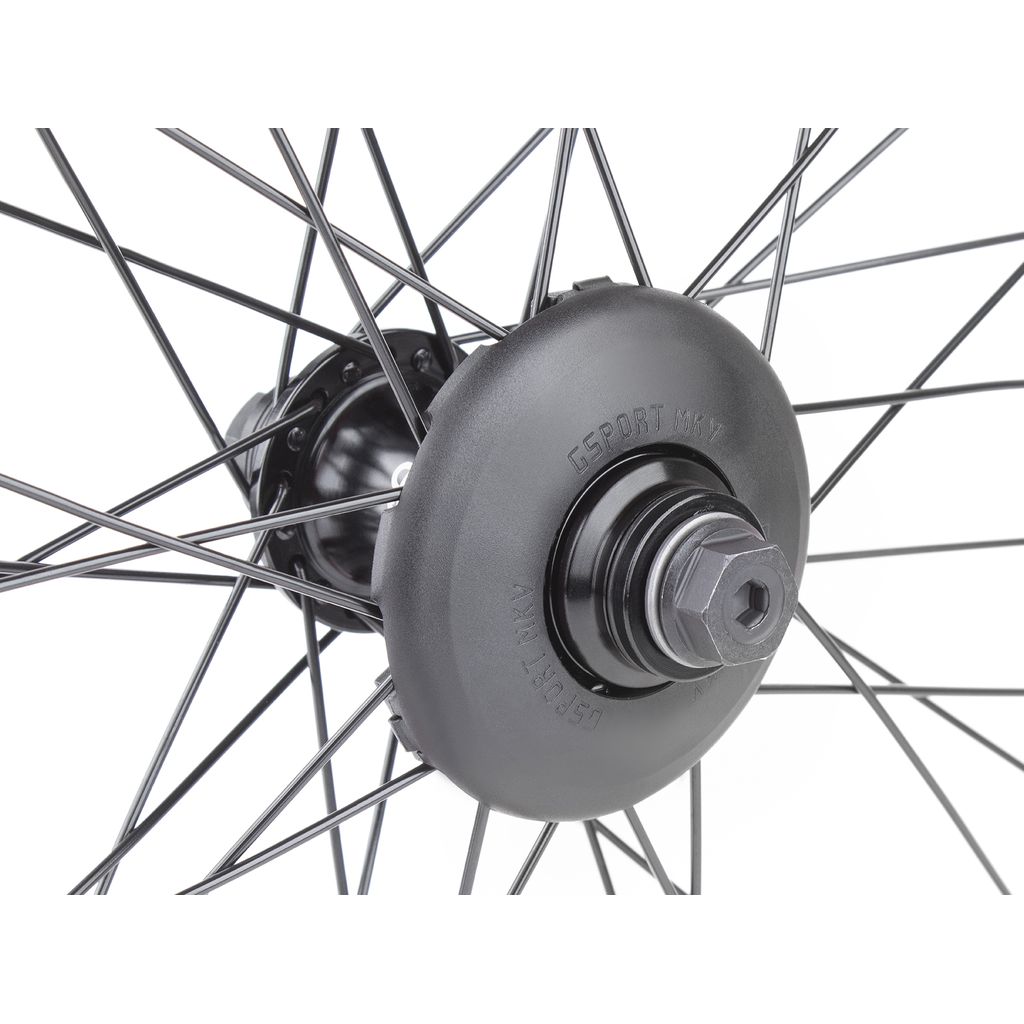 Close-up view of a bicycle wheel hub with black spokes. The central hub, labeled "LSport MX," features a metallic nut and the G Sport GLAND MKV Universal Front Hub Guard for added protection.