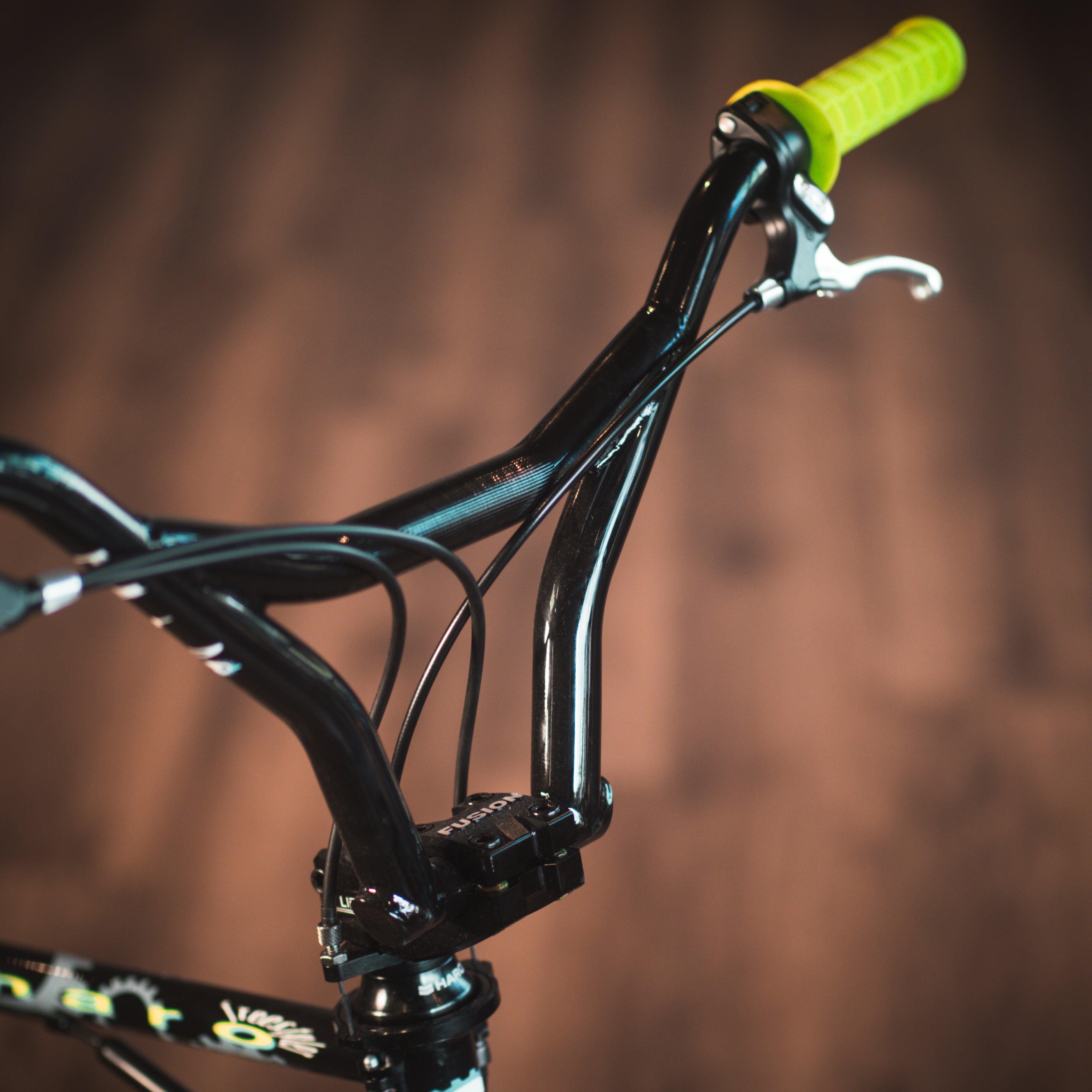 A close up of a Haro Lineage Sport Freestyler Bashguard 20 Bike with yellow handlebars.