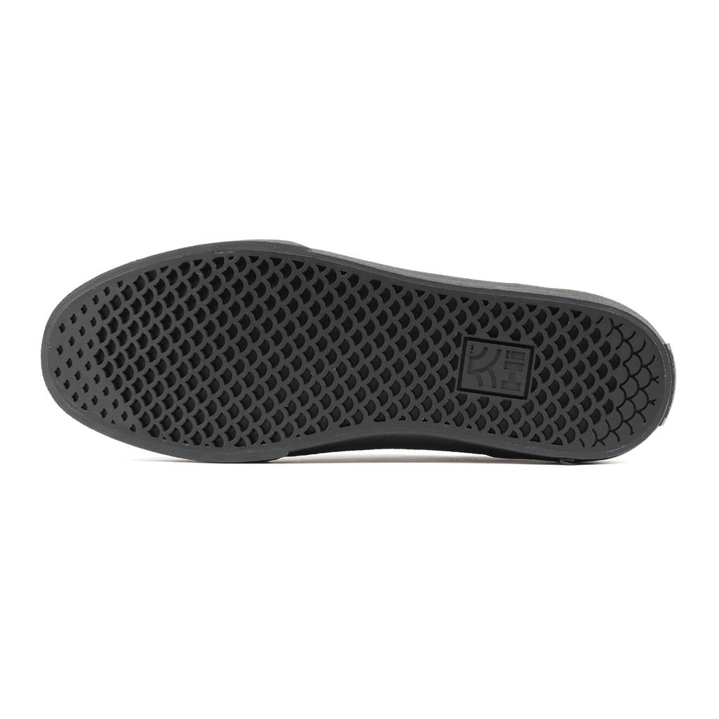 The image shows the black rubber sole of the Higher Crypt Canvas Lace Up Shoes (Raw Ecru/Black), featuring a textured hexagonal pattern and a rectangular logo area near the center for enhanced grip.