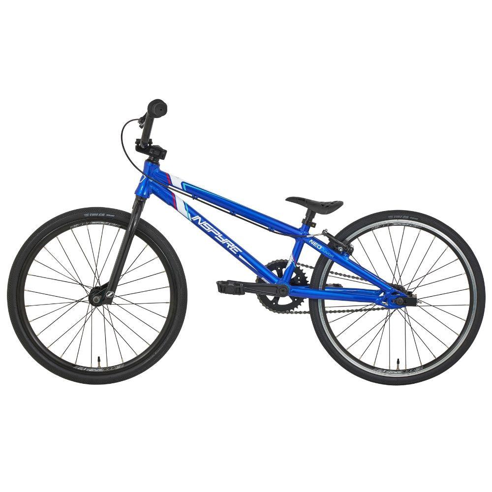 The Inspyre Neo Junior Bike 2025, featuring a blue frame, black wheels, straight top tube, flat handlebars, and a padded seat, is displayed on a white background—perfect for kids’ BMX racing.
