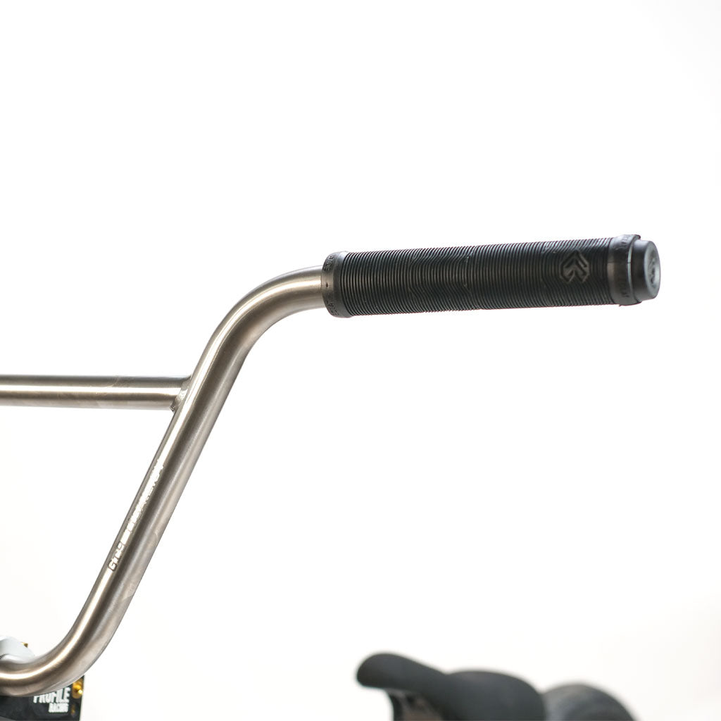 Metal handlebars with black rubber grips on an ION BMX TiXX 20 Inch Bike titanium frame.