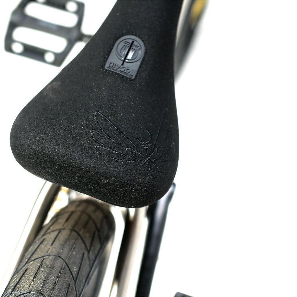 Close-up of a black BMX transition bike seat on an ION BMX TiXX 20 Inch Bike, featuring an embossed winged logo and a small circular emblem.