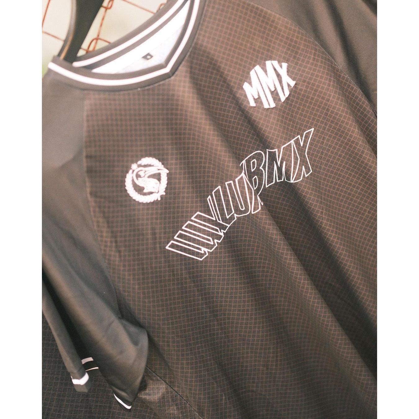 The LUXBMX MMX Soccer Jersey - Custom Back Print is a black and gray breathable jersey featuring white “MMX” and “LUXLUBMX” text on the front with a circular dragon logo—perfect for your next LUXBMX ride.