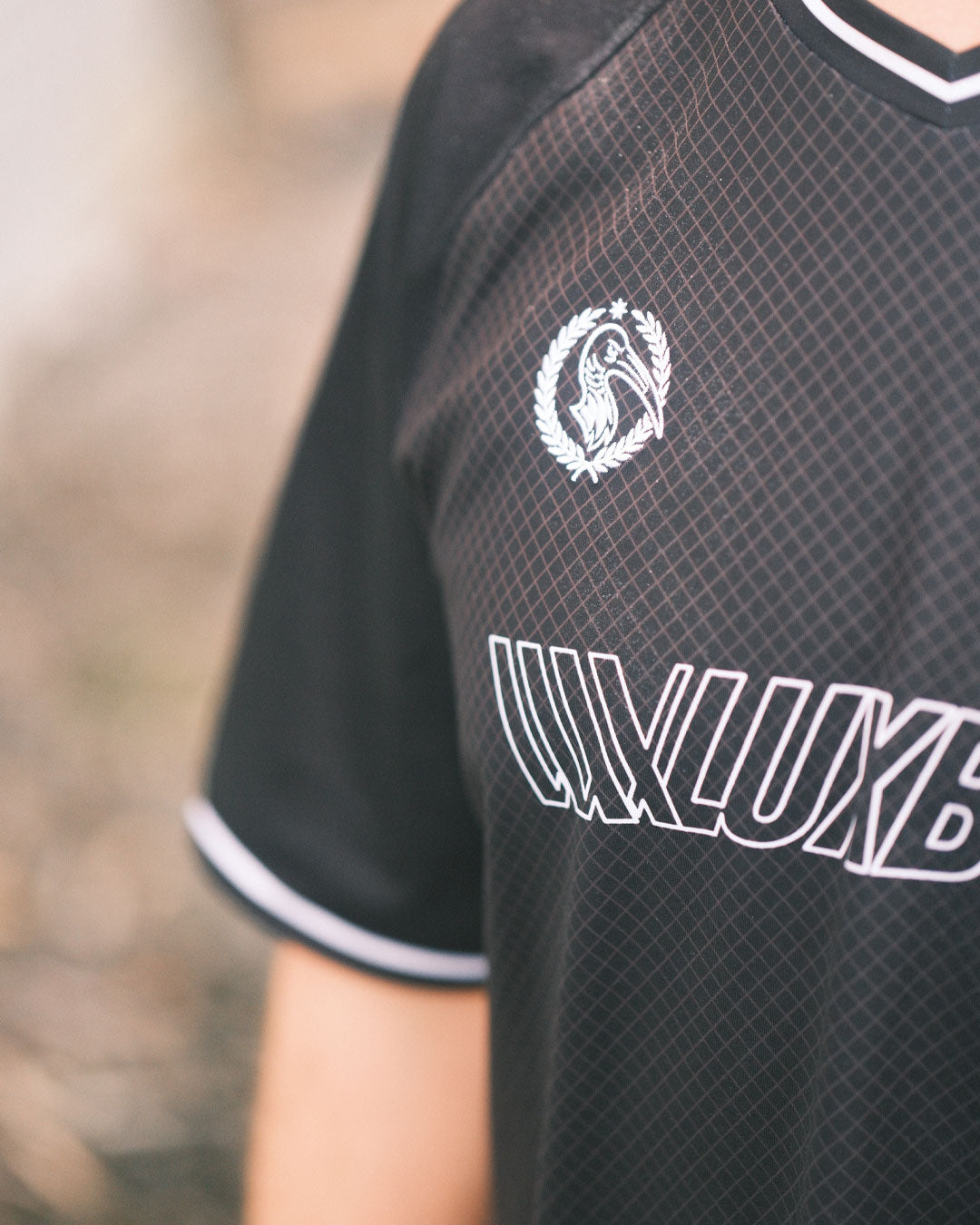 Wearing the LUXBMX MMX Soccer Jersey - Custom Back Print in black with white trim, featuring a lion in a laurel wreath and "LUXLUXB" on the chest—crafted for standout style and comfort.