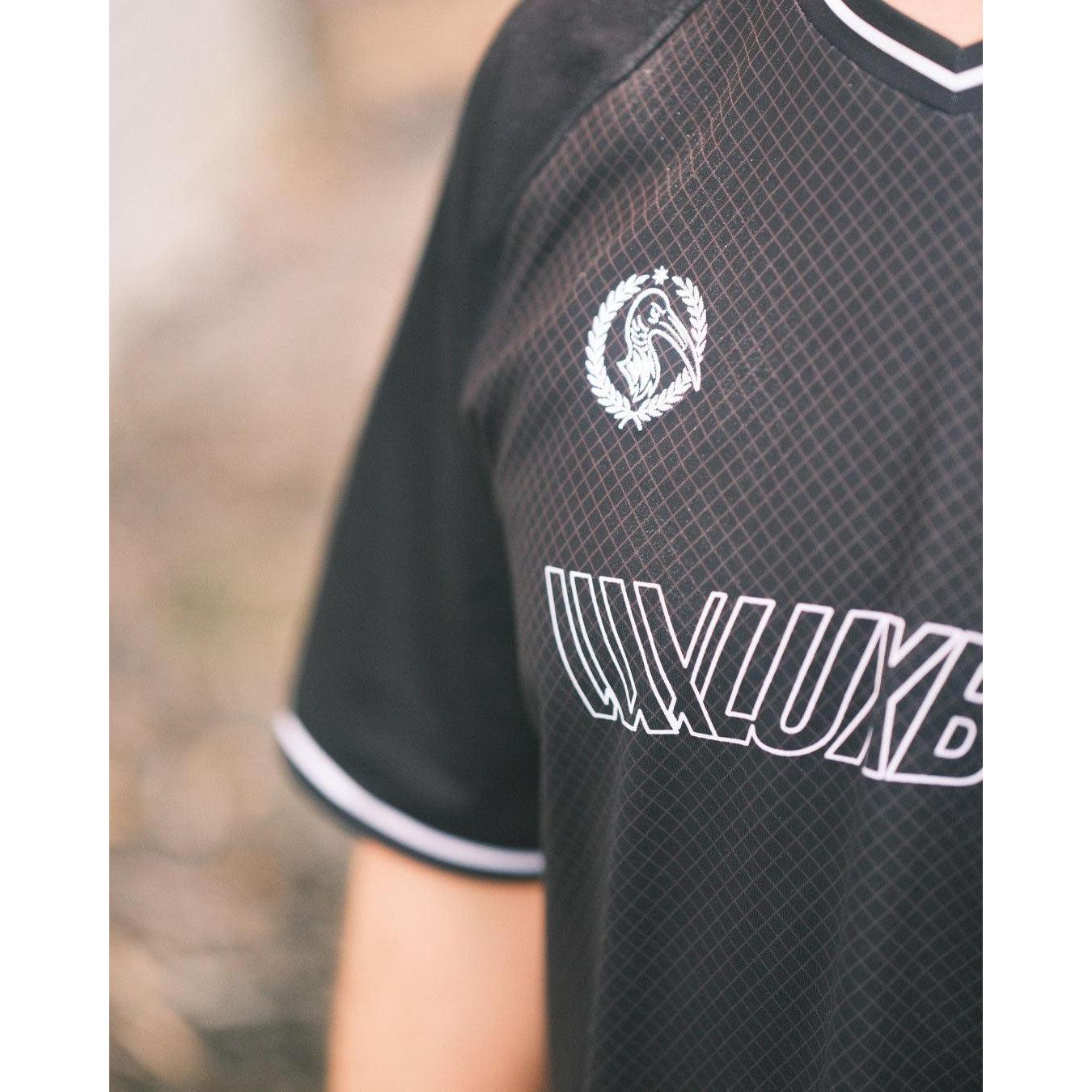 Wearing the LUXBMX MMX Soccer Jersey - Custom Back Print in black with white trim, featuring a lion in a laurel wreath and "LUXLUXB" on the chest—crafted for standout style and comfort.