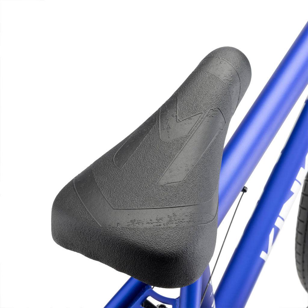 Close-up image of a black bicycle seat and the top part of a blue bike frame, showcasing the detailed textured pattern on the saddle. This Kink Curb 20 Inch Bike is ideal for riders seeking precision and style in their ride.