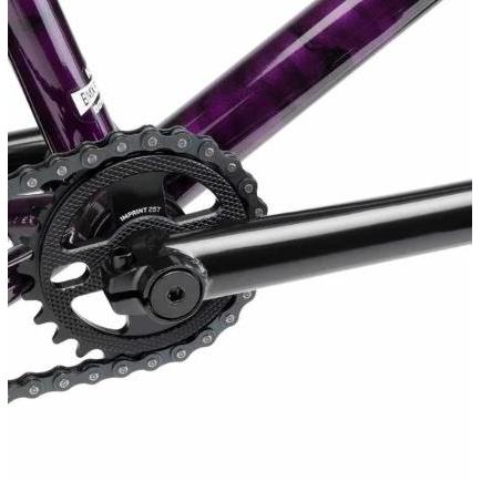 Close-up of the Kink Imprint Sprocket's black crankset and chainring on a purple frame, highlighting intricate gear details crafted from durable 7075-T6 aluminum.