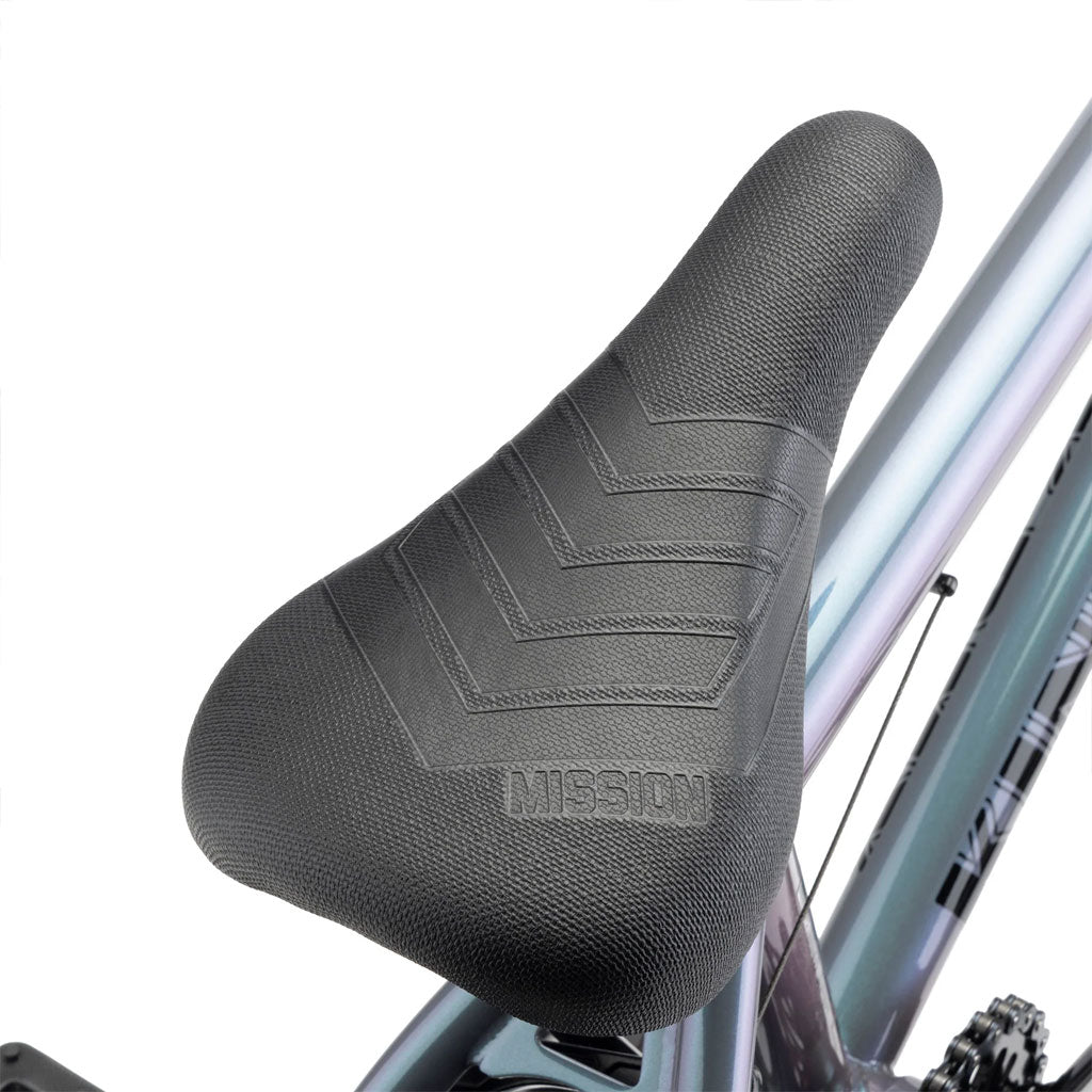 Close-up image of the Kink Kicker 18 Inch Bike seat with "MISSION" embossed at the back, attached to a metallic bike frame. Perfect for younger riders, this sleek design features high-quality components.