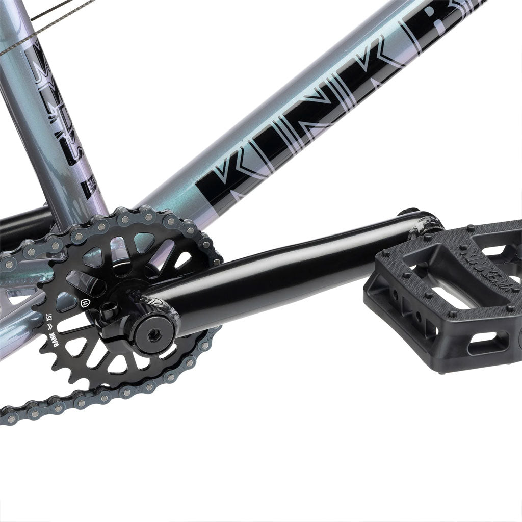 Close-up of a bicycle crankset, chainring, chain, and pedal mounted on a bike frame with the brand name "Kinkbike" visible. Ideal for younger riders, the Kink Kicker 18 Inch Bike features high-quality components designed to provide an exceptional riding experience.