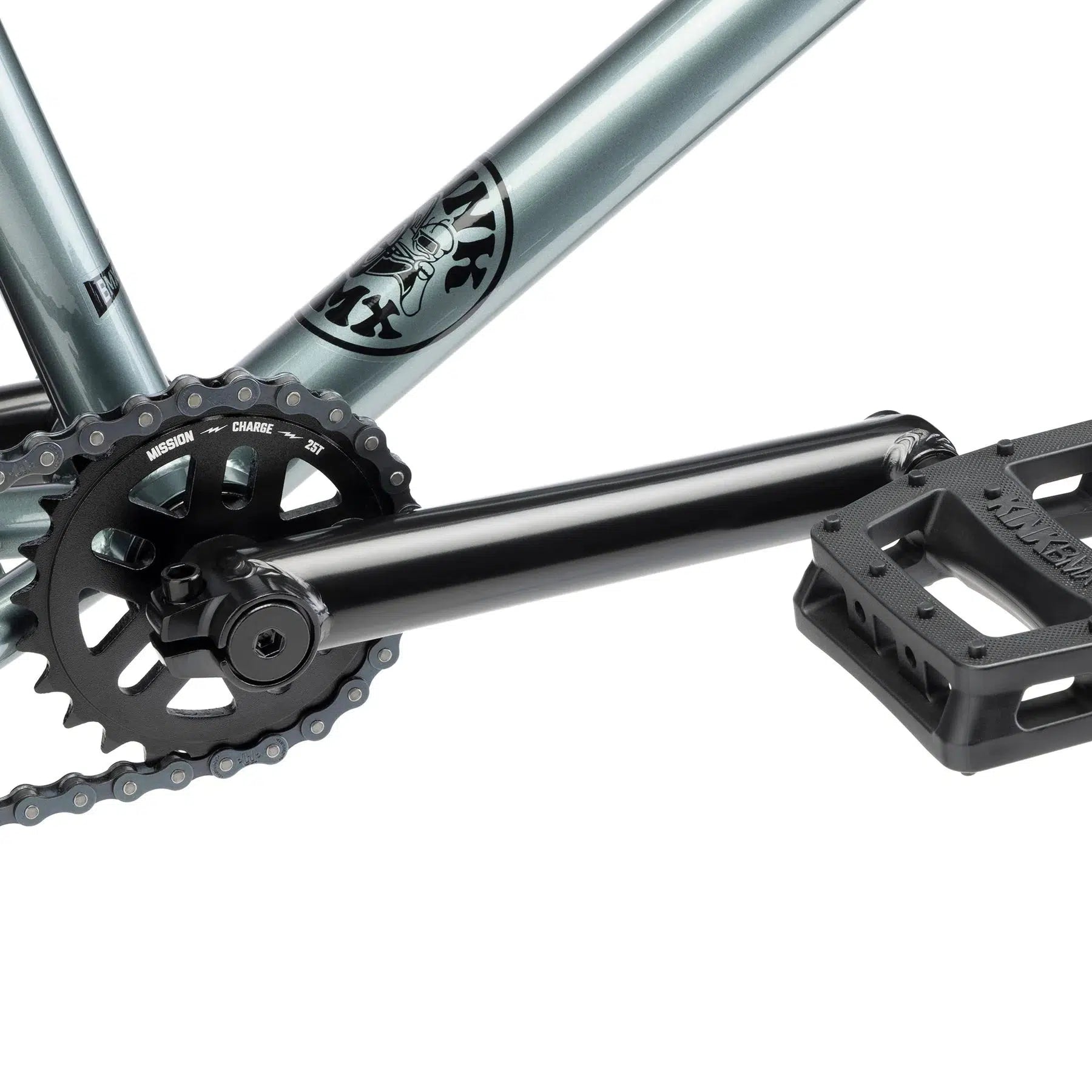 Close-up of the Kink Whip 20 Inch Bike's crankset featuring a black pedal and chainring, seamlessly attached to its sleek metallic gray chromoly frame.