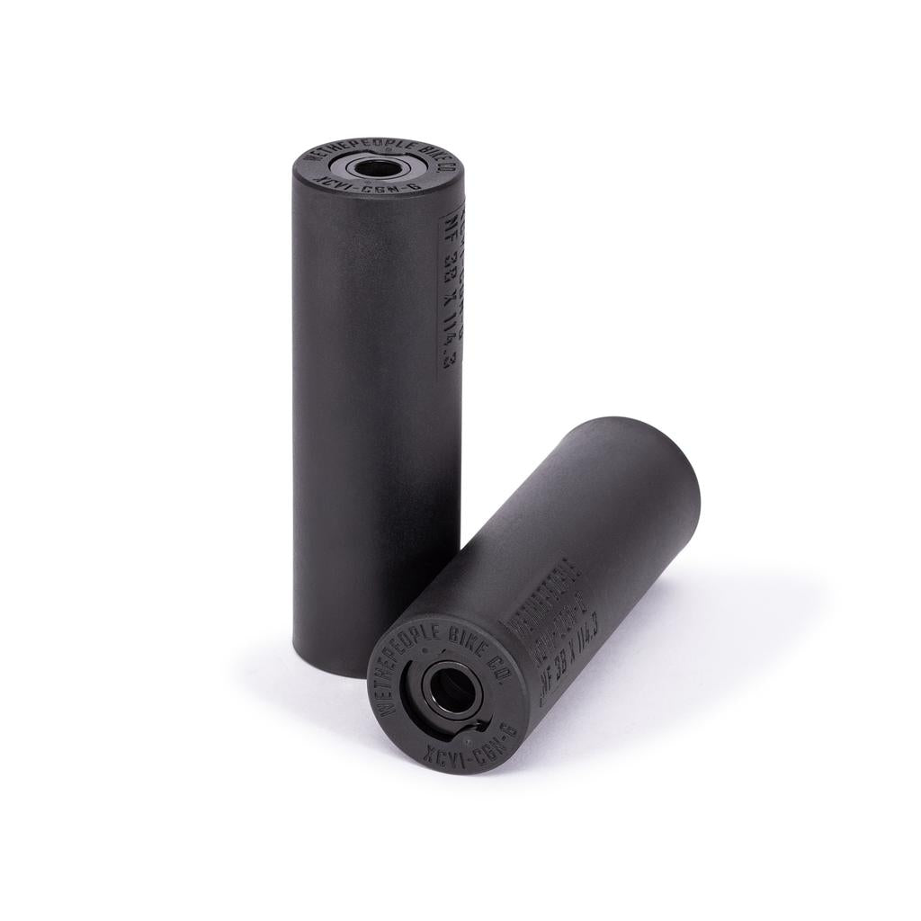 Two black Wethepeople Temper Pegs (Pair) are shown, one upright and one horizontal with visible markings. These BMX pegs feature a durable chromoly core for reliable performance in street and park riding.