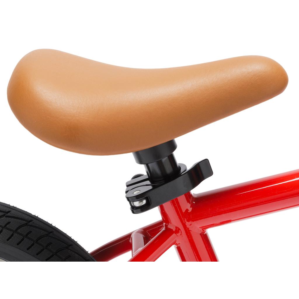 Close-up of the brown seat on the Fit Misfit 12 Inch Balance Bike, showing its red TIG welded steel frame and part of the rear wheel on the left.