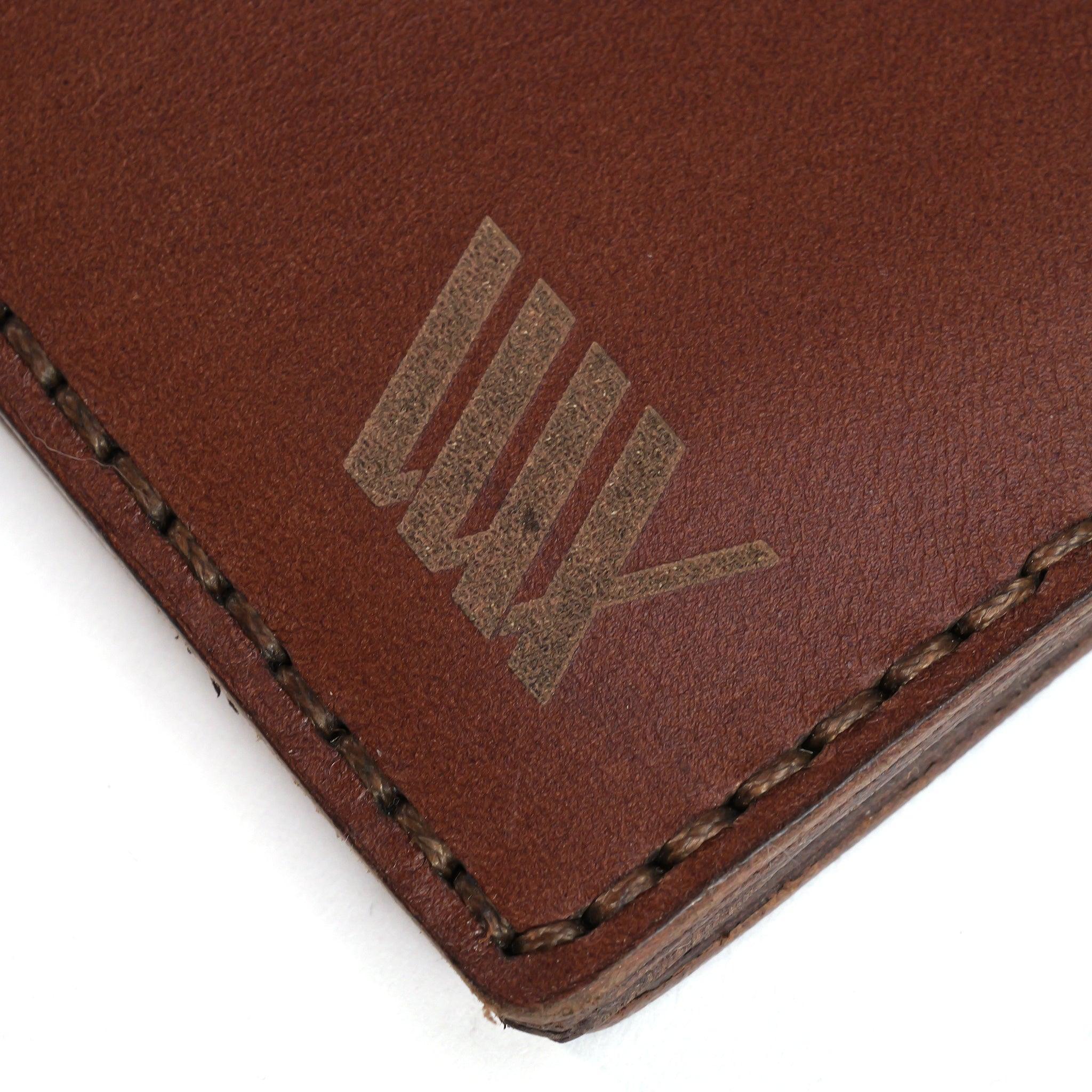 Close-up of the LUXBMX Bifold Leather Wallet, crafted from full-grain leather with visible stitching and "LUX" engraved in a stylized font. Handmade in Queensland.