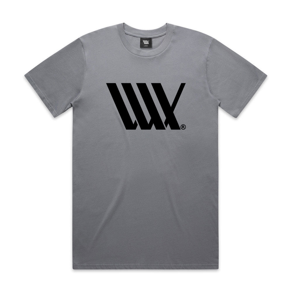 The LUXBMX Flag Tee - Gravel is a heavyweight gray tee featuring a bold black geometric "W" logo on the chest, inspired by the iconic LUXBMX Flag Tee.