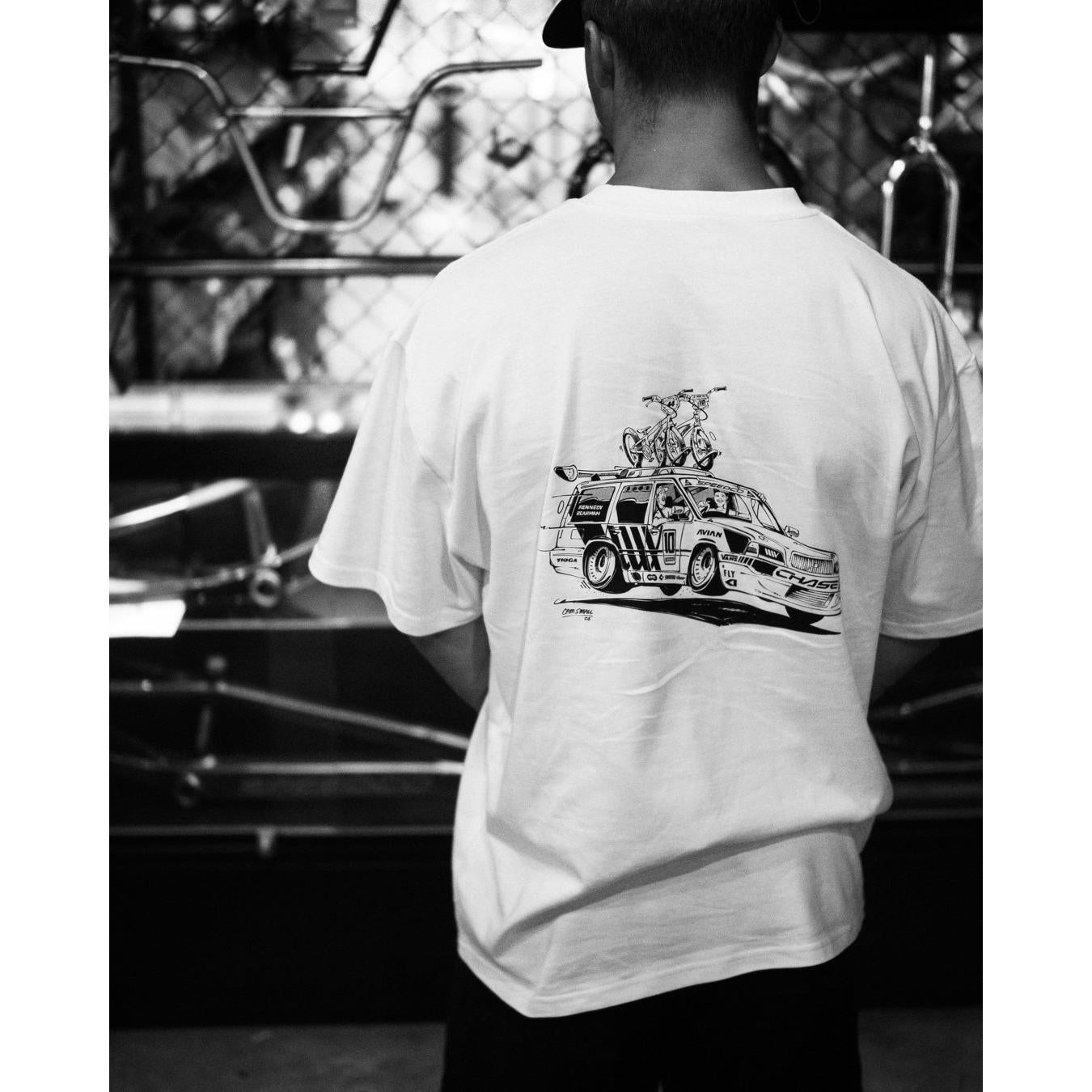 A man wearing a LUXBMX Izaac X Rico Kids Tee with a hand-drawn print of a car.