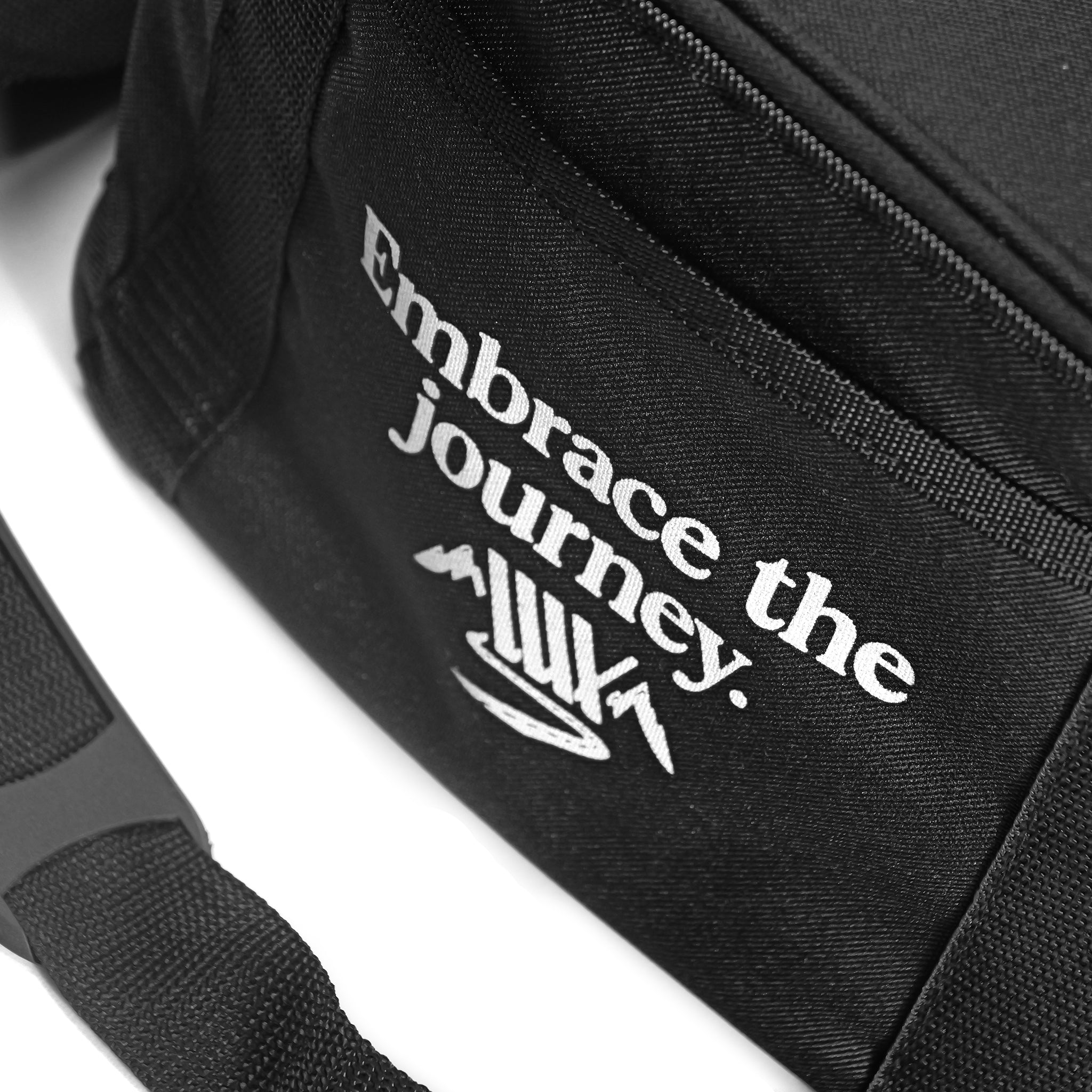 Close-up of the black LUXBMX Journey Cooler Bag, featuring "Embrace the journey." embroidered and a stylized mountain graphic on the front pocket, plus padded insulation to keep your essentials cool.