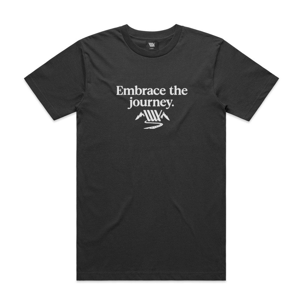 The LUXBMX Journey Tee - Coal is a relaxed fit shirt with "Embrace the journey." and a white print of stylized mountains and a winding path on the front, using soft discharge ink.