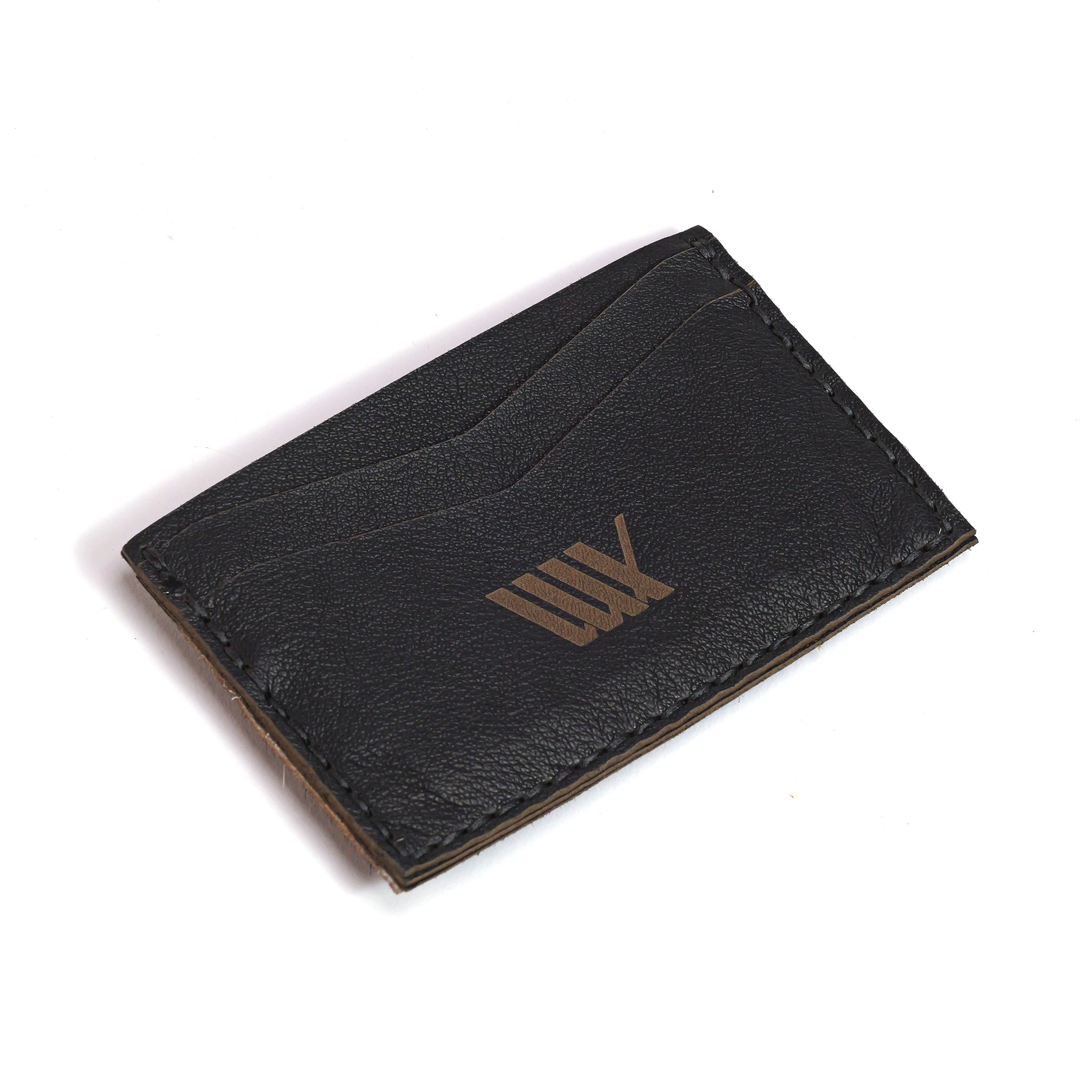 The LUXBMX Leather Card Holder is handmade in Queensland from black full-grain leather, featuring a stitched edge and a gold embossed geometric logo on the front. Photographed on a white background.