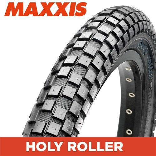 A close-up of the Maxxis Holy Roller 20 Inch Tyre highlights its versatility, featuring large square knobs and an inverted knob design, with the Maxxis branding visible on the sidewall.