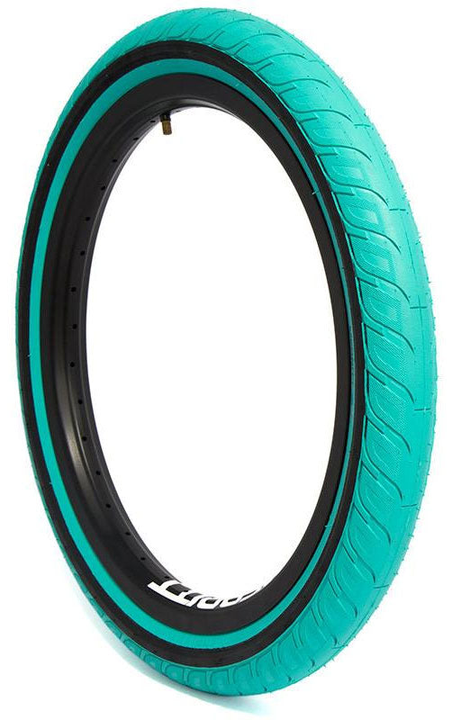A teal-colored Merritt Option 20 Inch Tyre (Each) featuring Slidewall Technology with a black inner rim, shown standing upright against a white background.