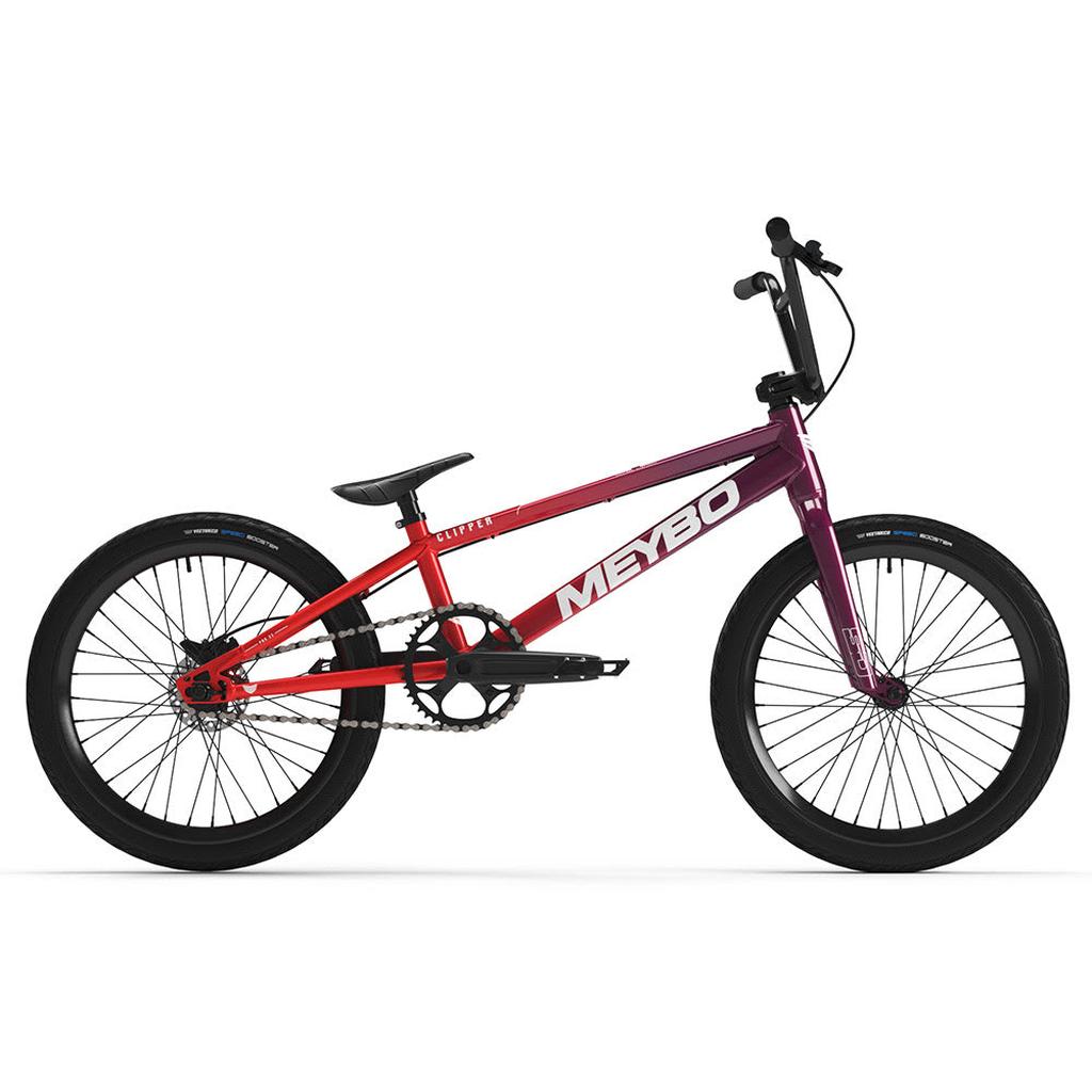 The Meybo 2025 Clipper Pro XXL BMX race bike features a gradient red to purple frame, black handlebars, seat, and wheels, along with a visible chain and pedals. Designed for speed and style on the track.