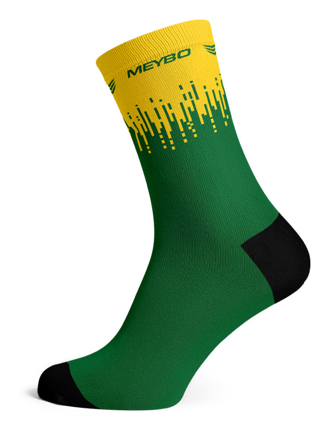 Certainly! Here’s a rewritten version using the product data: The Meybo Sock Ribbed Crew features a green body with a yellow band at the top, yellow geometric design, black heel and toe, and “MEYBO” text near the cuff—making these socks perfect for your next road adventure or relaxing recovery ride.