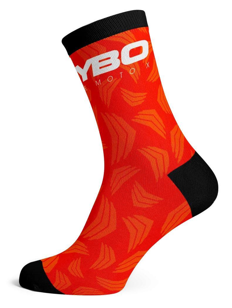 The Meybo Sock Ribbed Crew Sock is bright orange with black heel, toe, and cuff. It features a white "YBO" logo and lighter orange angular patterns—ideal for racing or making a statement on the dance floor.