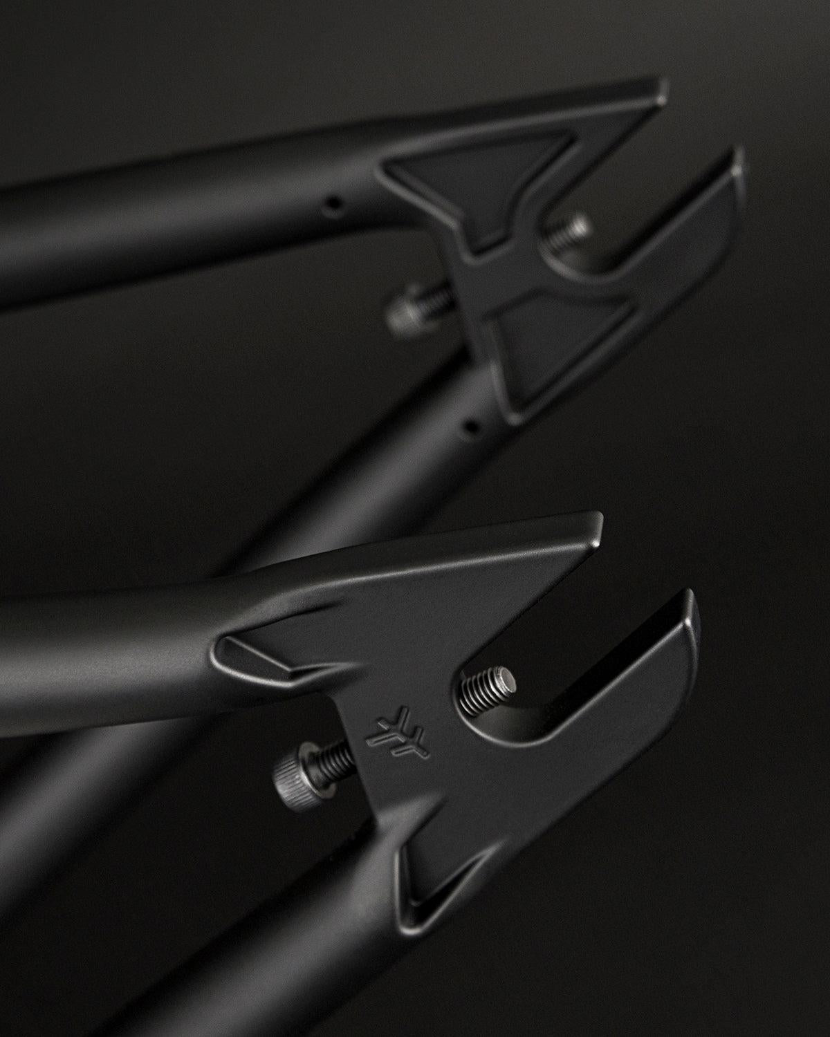 Close-up of black bicycle dropouts with a sleek, modern design against a dark background, showcasing the Fly Bikes Sierra 18 Inch BMX frame.
