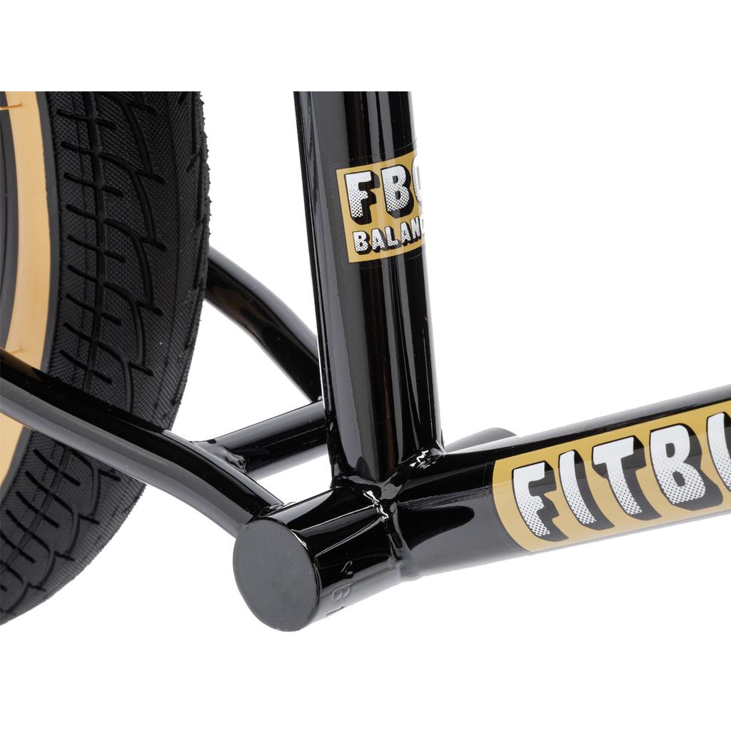 Close-up of TIG welded steel frame on a black Fit Misfit 12 Inch Balance Bike, featuring "FITBIKECO." and "FBC BALANCE" stickers at the tire and frame junction.
