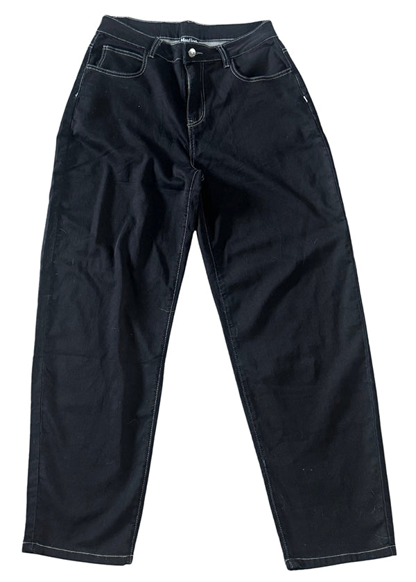 The Monticule Flow Pants by Max Miller are black baggy-fit denim jeans with white stitching, inspired by classic BMX pants. They feature front pockets and a button closure, shown laid flat on a white background.