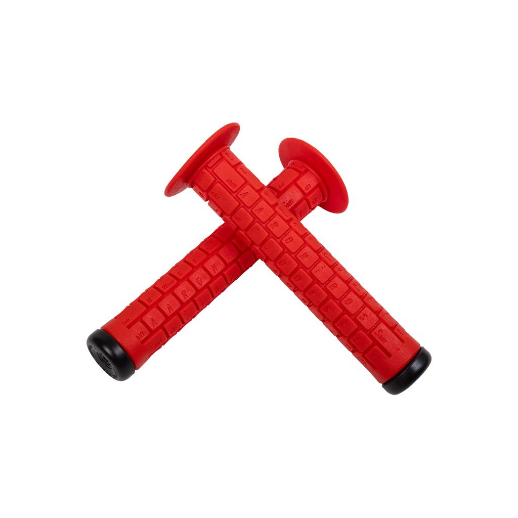 Two red Odyssey Aaron Ross Grips, each 145mm with black end caps, are crossed on a white background—designed for a soft feel and signature style.