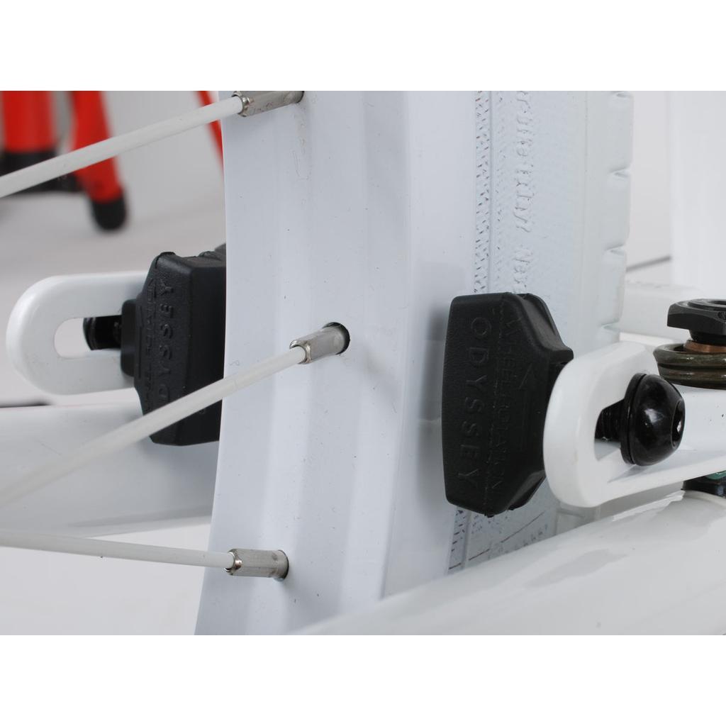 Close-up of an Odyssey Ghost Pads bicycle component with brake cable and black adjustment knobs on a sleek white aluminum frame, showcasing precision in every detail.