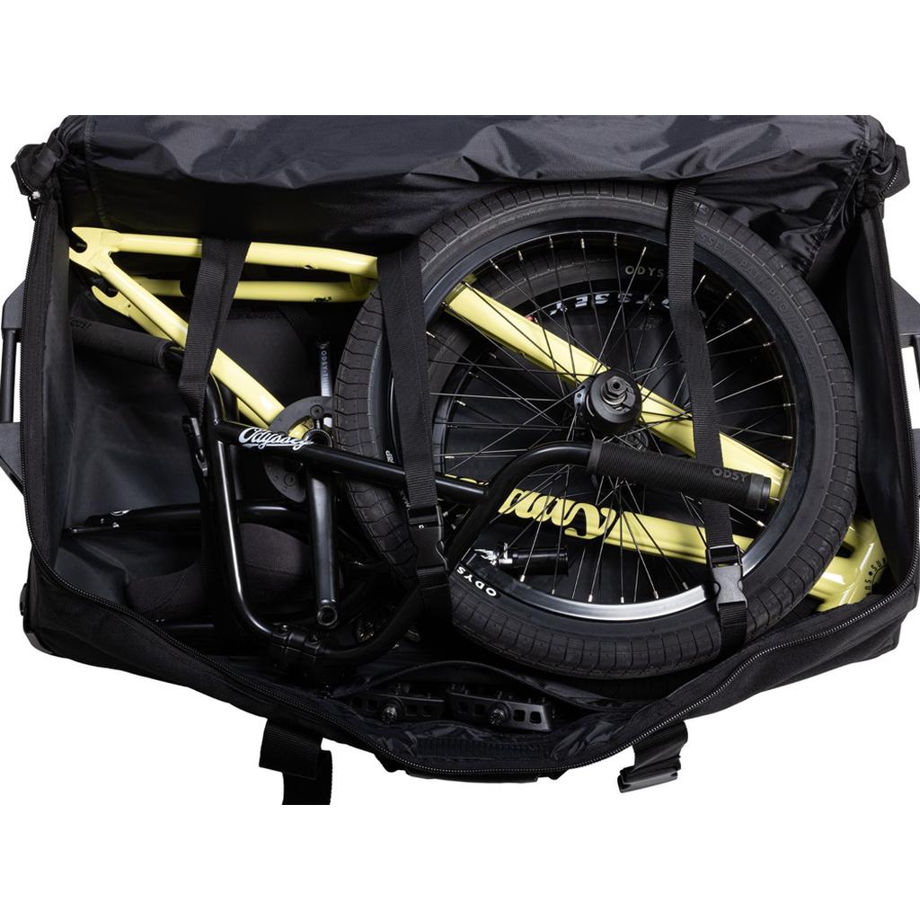 A partially disassembled yellow BMX bike, including the Odyssey Traveler Pro Bike Bag, is neatly packed inside a large black bag.