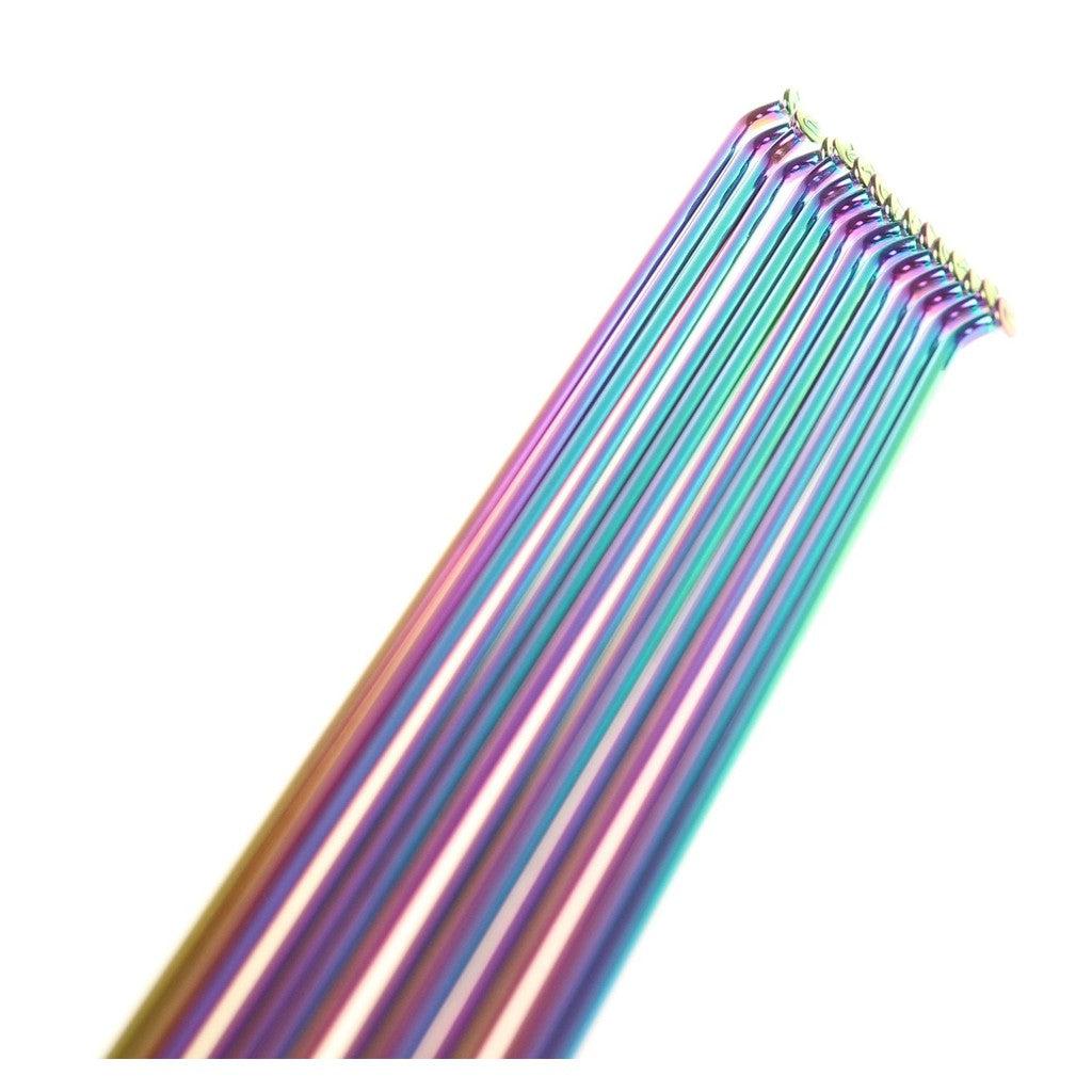 Close-up of vibrant, oil-slick Pillar PSR 14g spokes arranged diagonally against a white background, resembling sleek stainless steel knitting needles.
