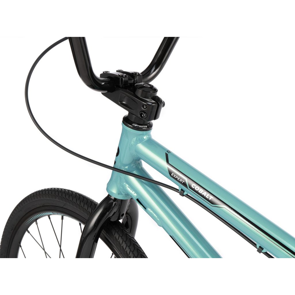 Close-up of the front part of a teal BMX racing bike, showing the handlebars, brake cable, and the Radio Cobalt Expert Bike model name on the frame from Radio Raceline.