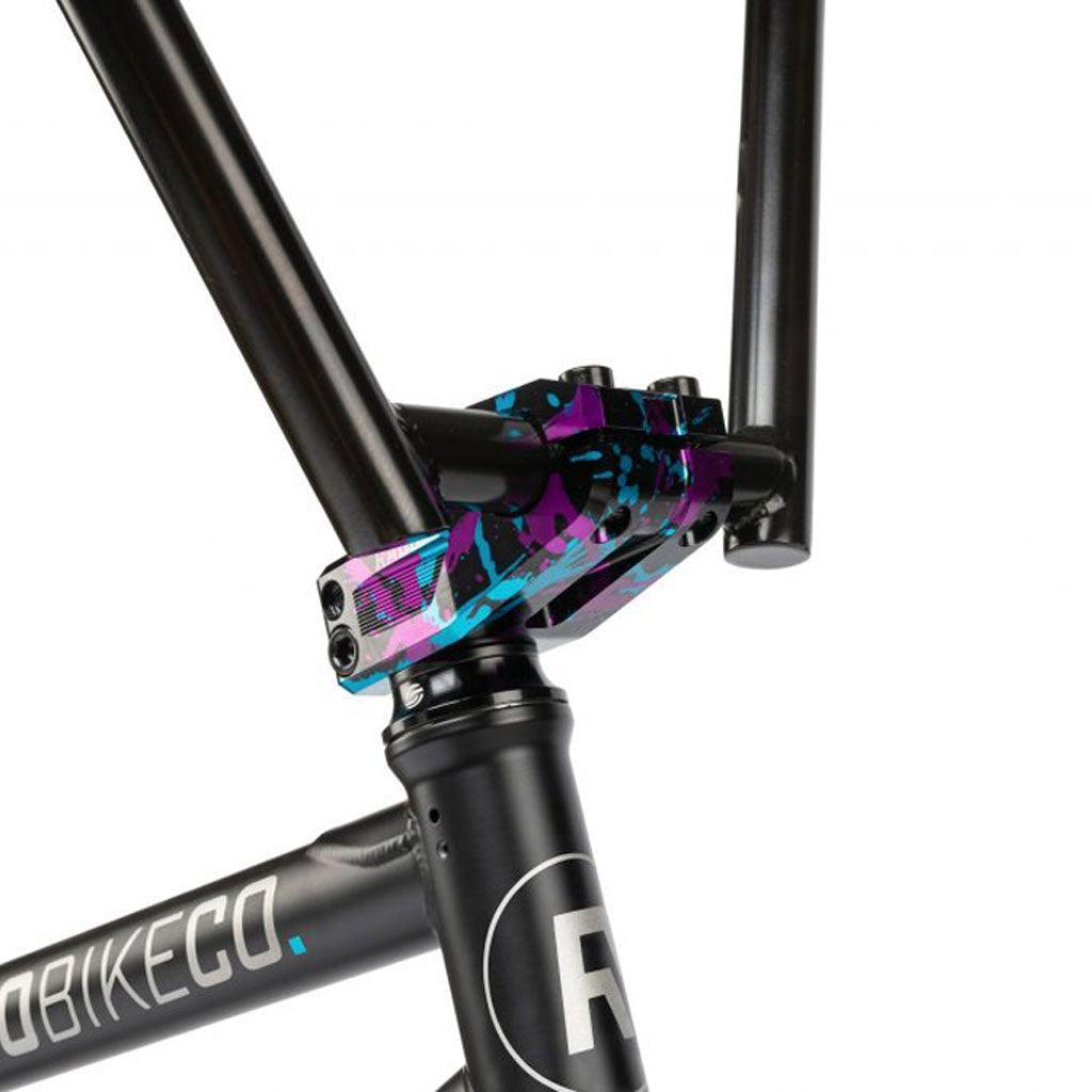 Close-up of a Radio Comrad 20 inch Bike's black frame featuring a vibrant blue and purple stem clamp, highlighting its full Cromoly frame that seamlessly connects the handlebars.