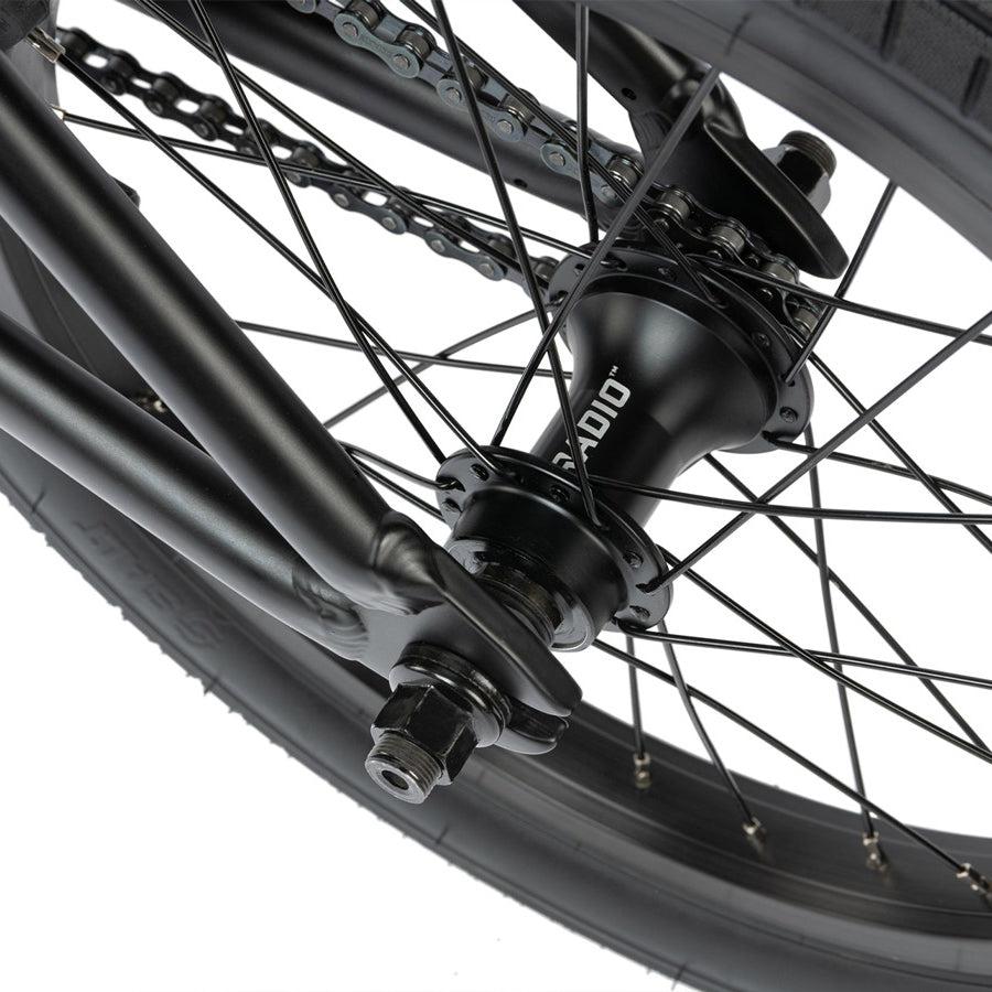 Close-up of a Radio Dice 16 Inch Bike's rear wheel showing the spokes, hub, chain, and part of the tire against a white background.
