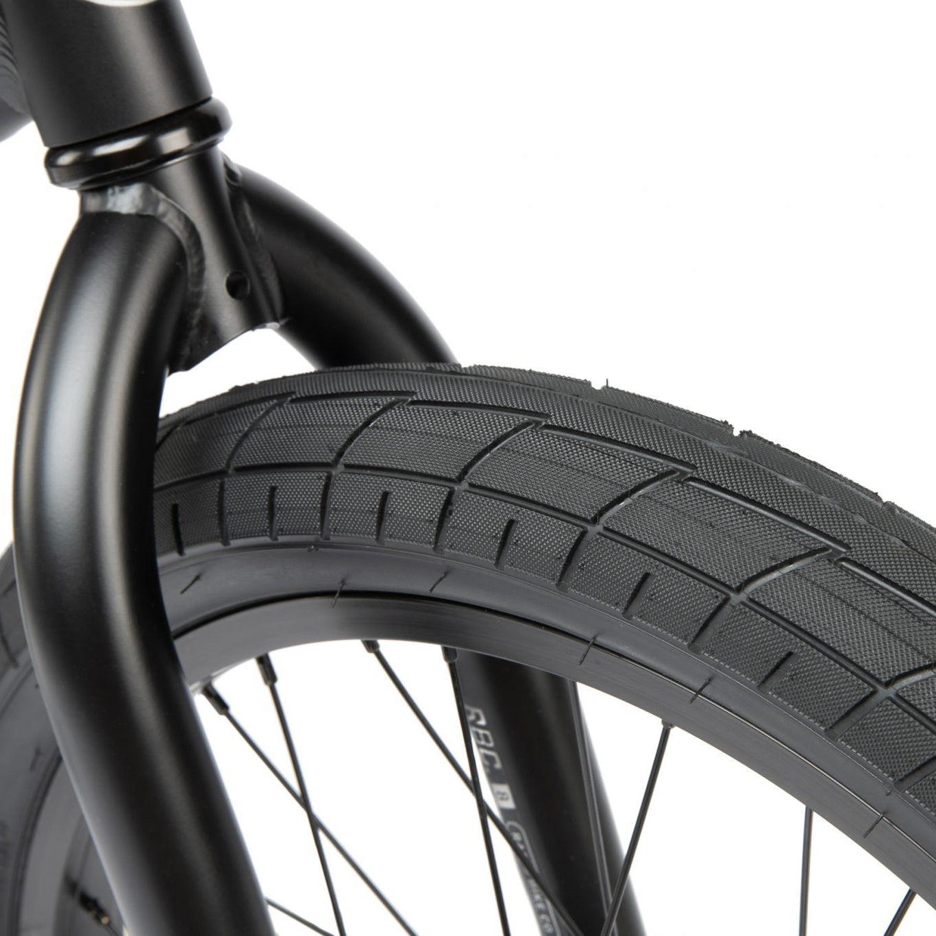 Close-up of a black bicycle wheel with a Radio Dice 20 Inch Bike, showing the tire, rim, and spokes with a portion of the 6061 Alloy Frame visible.