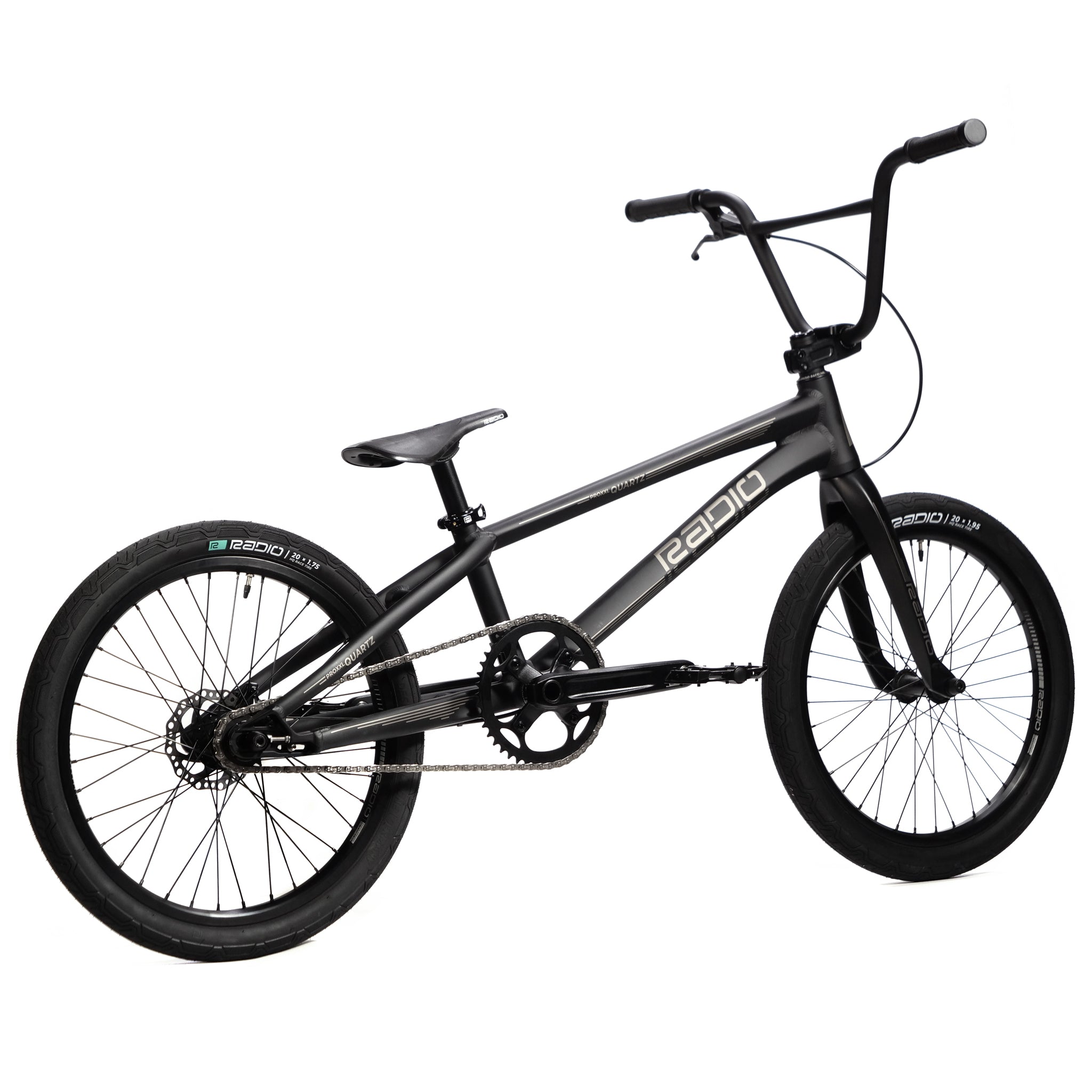 The Radio Quartz Pro XL Bike 2025 boasts a compact, lightweight black hydro-formed frame with a "Radio" logo. This model features large tires, a single gear, and raised handlebars, paired with superior handling courtesy of the Radio Solar carbon fork.