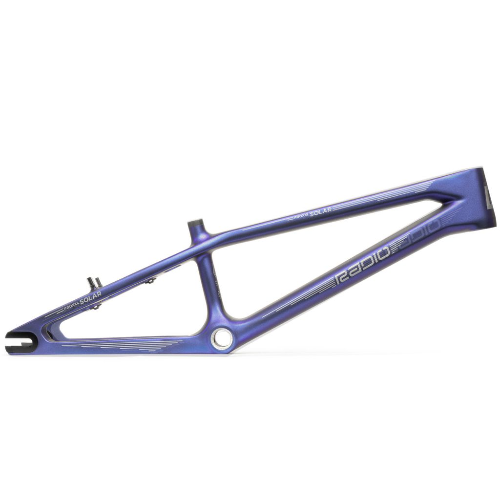 A blue bicycle frame labeled "Radio Raceline Solar Carbon Pro XXL Frame", crafted from Torayca carbon, boasts a sleek, minimalist design with a large opening in the middle and aerodynamic lines. The internal cable routing adds to its streamlined elegance, ideal for a high-performance ride.