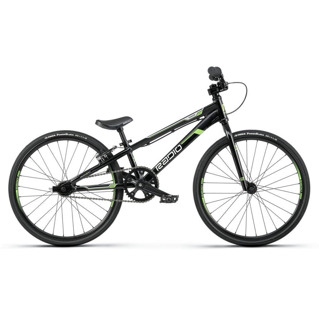 A black BMX race bike with green accents, the Radio Xenon Mini Bike features a sleek frame made of hydro-formed 6061-T6 alloy, straight handlebars, and thin tires designed for racing.