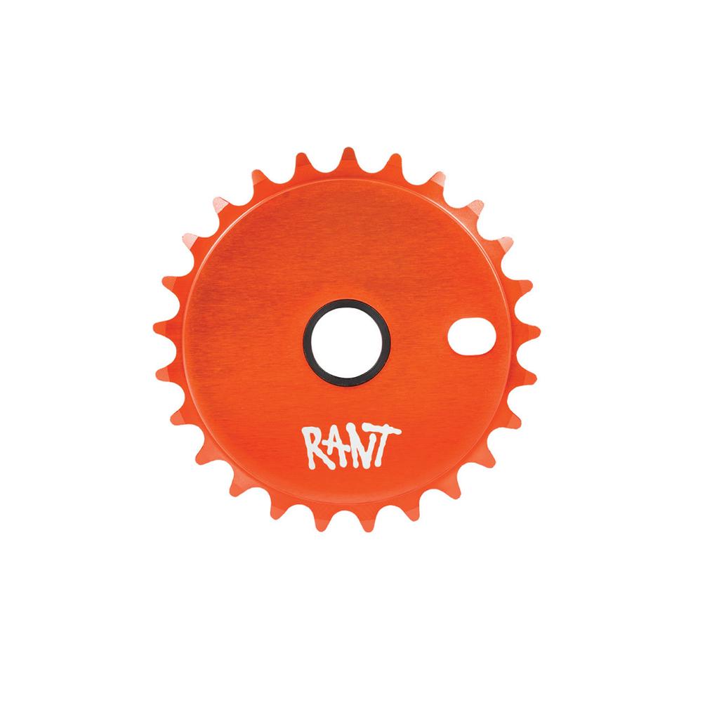 The Rant Stick Em Sprocket is an orange bicycle sprocket with a round center hole, an oblong cutout, and features the word "RANT" in white text.
