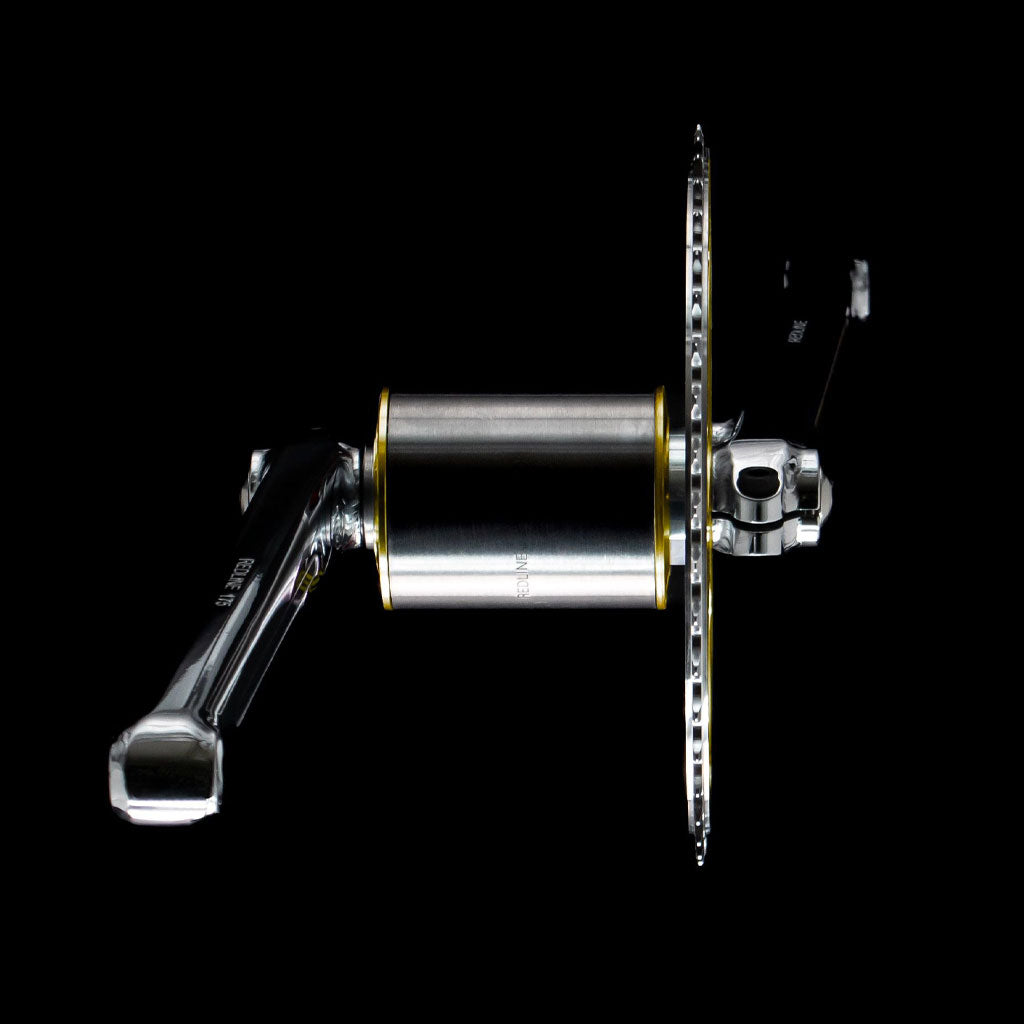 The REDLINE Flight 401 50th Anniversary Crank Set, featuring crank arms, bottom bracket assembly, and chainring, shown isolated on a black background—an iconic choice for collectors.