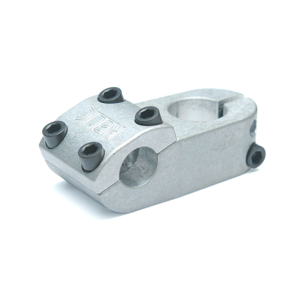 The Relic Elect Stem Top Load is a silver metal bike stem with black bolts and a circular opening for attachment, perfect as a lightweight option for your mountain bike.