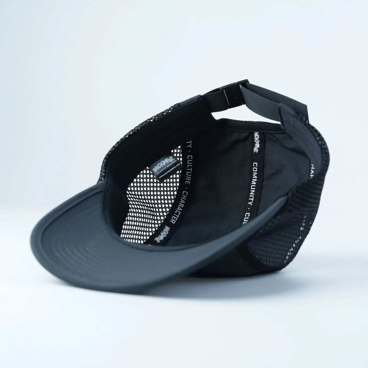 The Backbone Ride Club Hat is shown upside down, displaying its adjustable strap and inner tape with printed text, making it a perfect choice for anyone seeking a classic runners style cap or Ride Club hat.